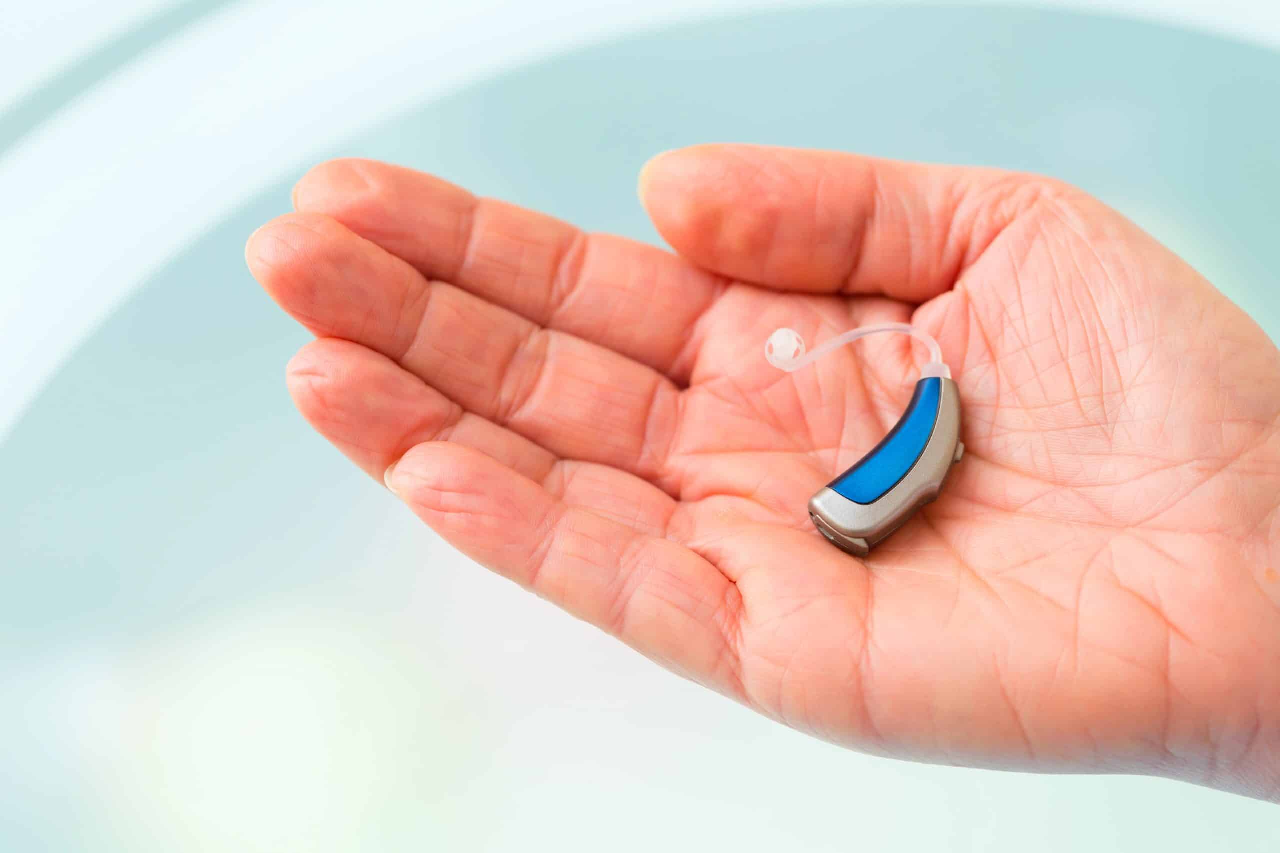 hand holding a hearing aid on hearing aid tips and tricks page
